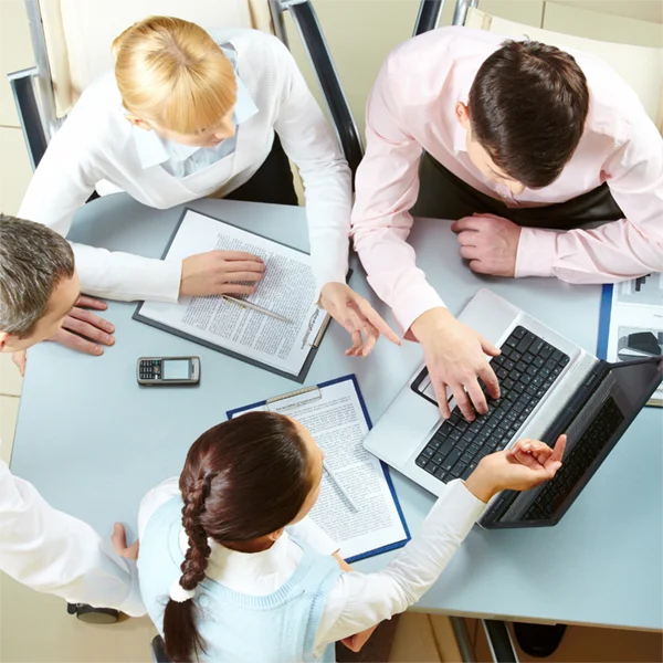 Workers looking at laptop or round table